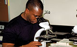 Photo: African-American medical student looking into microscope